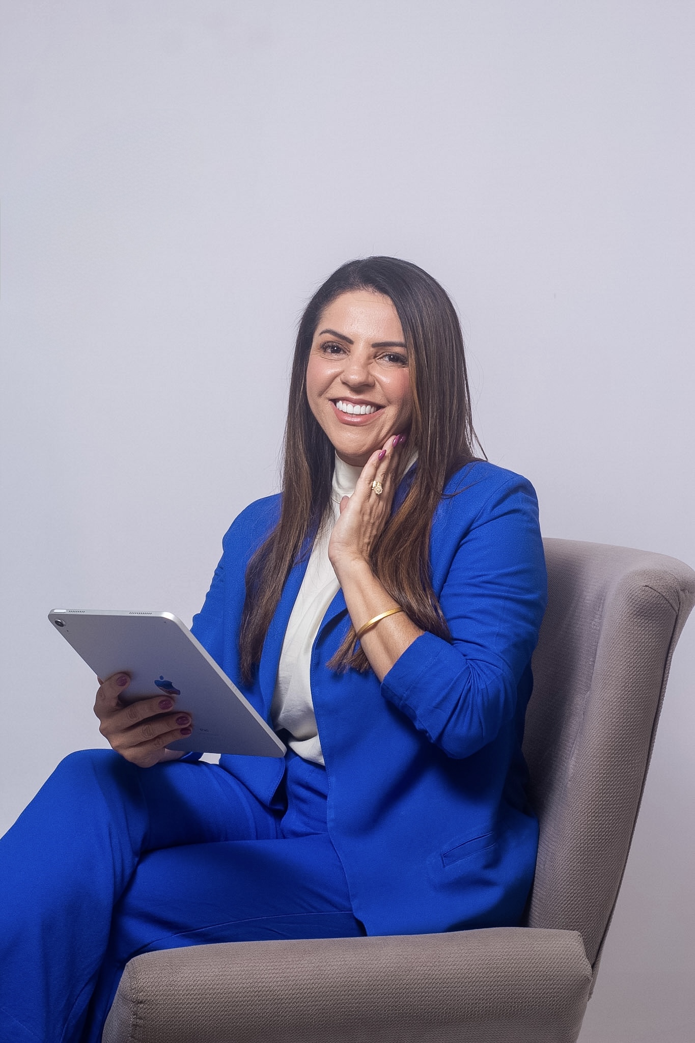 Penha Bernardes com blazer azul e tablet